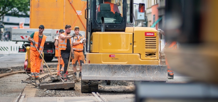 Des ouvriers travaillent sur un chantier routier avec un engin de chantier