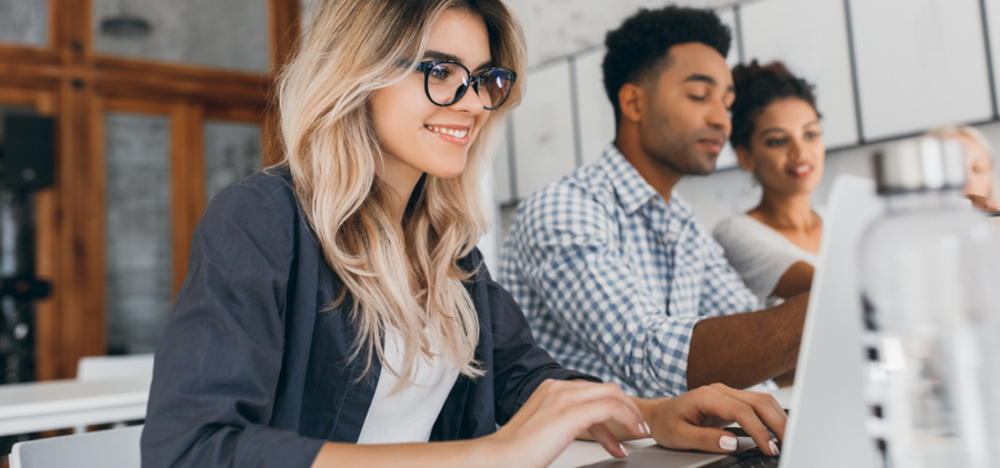Une secrétaire travaille sur son ordinateur portable avec ses collègues